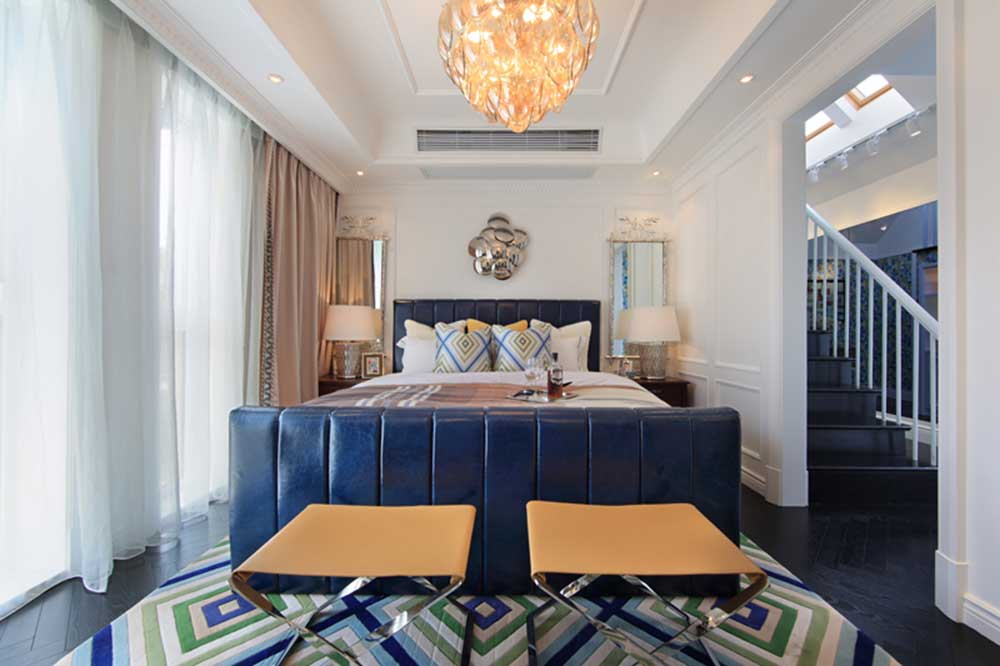 对称设计的卧室庄重典雅，客厅同款的地毯和水晶灯统一整体风格。