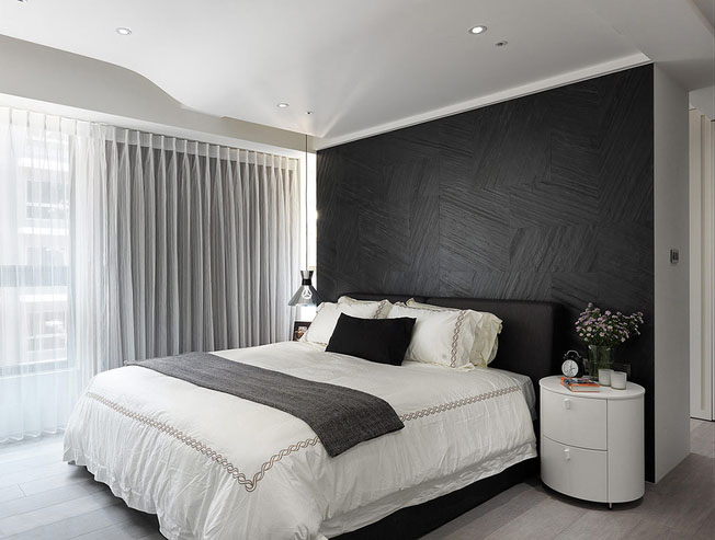 整体风格延续至卧室，黑白两种色差极大的搭配方式，在纱质窗帘的映衬下，多了一种朦胧美。
