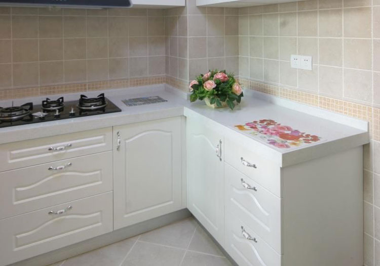 洁白的整体橱柜搭配浅黄色瓷砖，为单薄的厨房增加暖度。