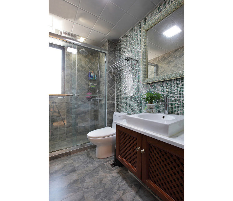 卫生间的灰绿色马赛克瓷砖精致时尚，木作浴室柜将田园气息充分显露了出来。