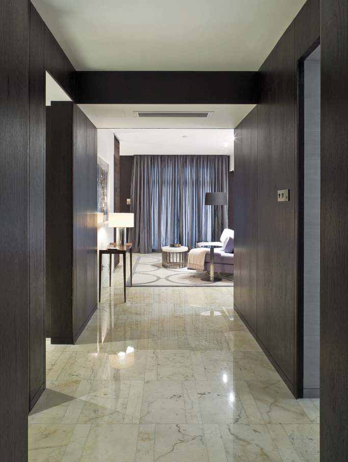 米色瓷砖从玄关过道一直铺贴到客厅，整体连接扩大空间的视觉感，黑色的木质墙面缓解了瓷砖的冰冷感，并显得大气低调。