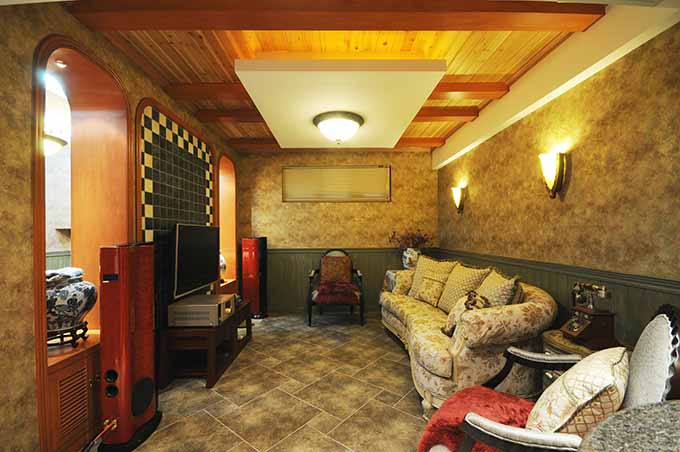 客厅的美在于花色的沙发和烟灰色的地板以及原木色的天花板相互户型，墙壁和地板颜色相近，融为一体。