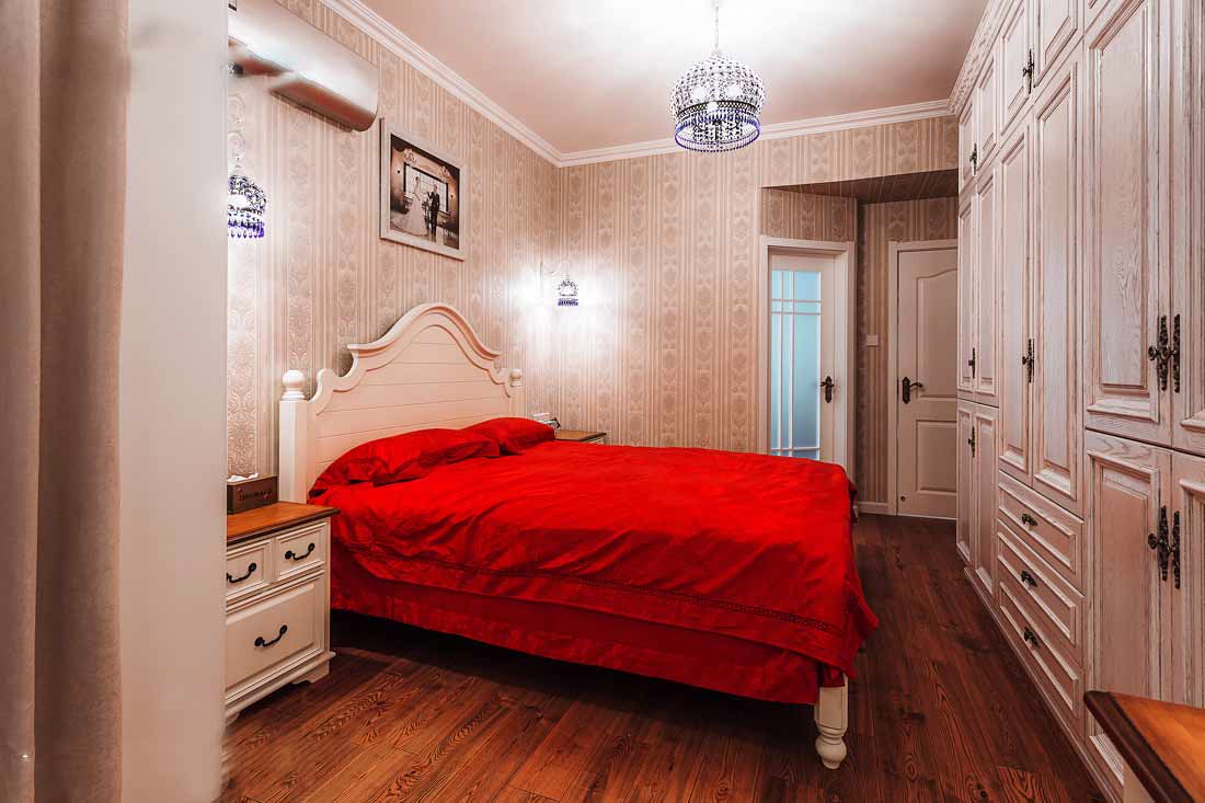 水晶吊灯十分精美，墙纸的图案复古怀旧，红色的床上用品，凸显了主人的热情。