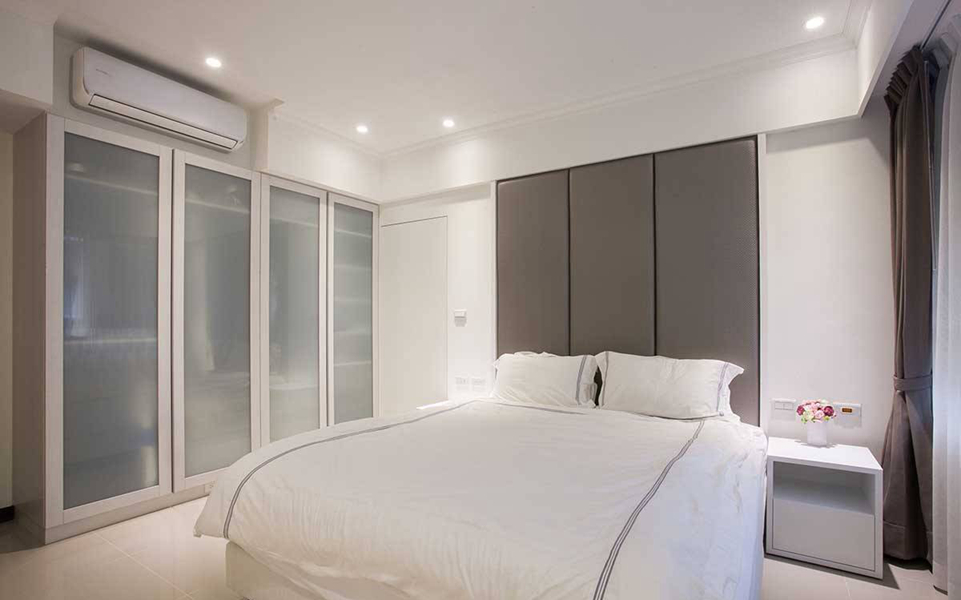 以绷布处理的床头，衔接上暗门设计，将卫浴与更衣间入口做了协调整合。