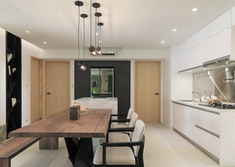 完全开放式的餐、厨空间里，大型电器与收纳柜体收整于单一立面，以俐落态度简化空间线条。