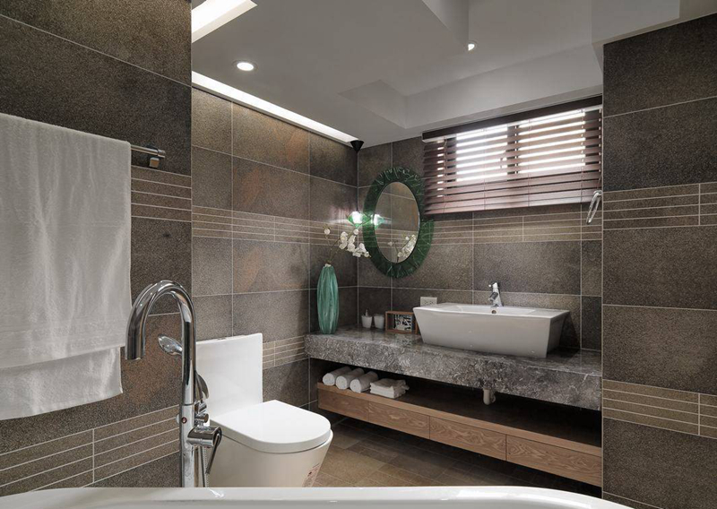 配合采光微调的卫浴空间，家私搭配时，设计师翁嘉鸿仍不忘以女主人最爱的绿色系琉璃作为镜面边框细节。