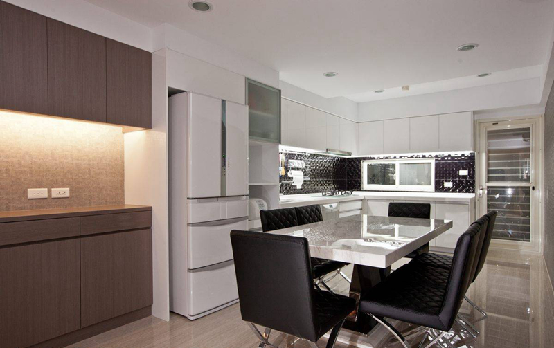 由木质餐柜与白色系统餐柜衔接，黑白色调呈现前卫的餐厨空间。