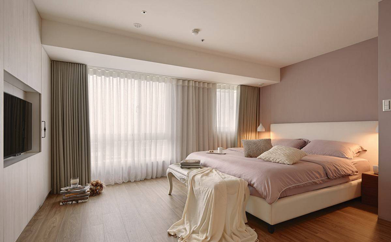 床铺避开贴近采光的梁体，以俐落简洁的立面收纳起衣物与视听机能，创造单纯宽适的主卧空间。