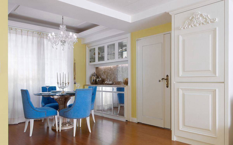 蓝色的餐椅，璀璨的水晶吊灯，镜面腰柜门片与白色背景基调成为强烈对比。