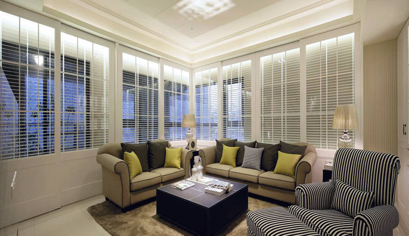客厅选用亚麻布沙发与跳色抱枕呈现舒适质感，地毯与壁纸则以大地的色调，围塑空间暖意。