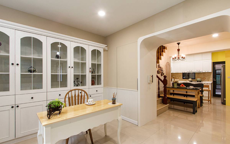 利用弧形拱门设计串联起居室与餐厨区的动线，运用墙面的厚度规划出收纳空间，并以隐藏门片维持整体设计感。