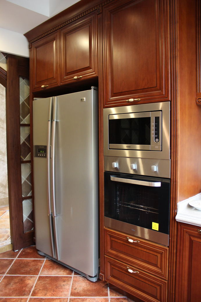 厨房用一个整体柜收纳了冰箱和烤箱，整体看上去整齐划一。