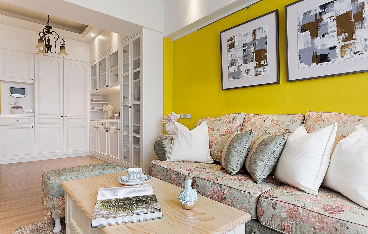 客厅其中的一面墙被涂上了黄色乳胶漆，让素雅的空间明丽起来。