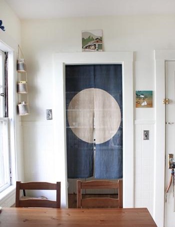 日式的门帘代替了门的作用，隔开厨房和餐具收纳间，节省了门的购置、安装费用。墙壁上挂上几幅从日本带回来的油画，让厨房有和风的元素，给人悠闲的宁静。