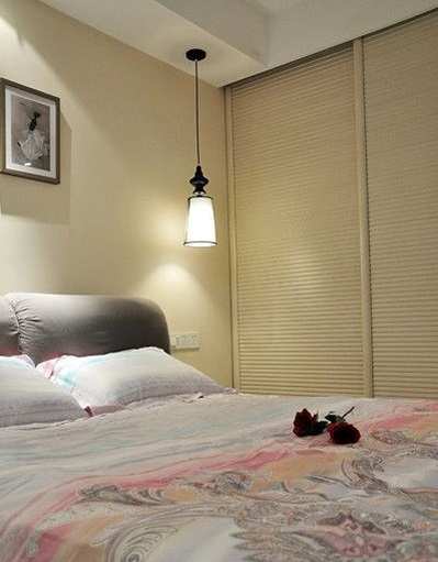 一盏简单的吊灯足以温暖整个起居空间。布艺设计的床头呈现了柔软而温馨的特质。