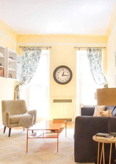 鹅黄色的墙面让客厅有了温暖的色调，地毯是地面上不可或缺的一部分，深蓝色沙发与橙色茶几形成色彩的碰撞，有限的客厅空间拥有着无限的活力。