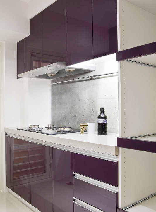 厨房采用紫色厨柜搭配白色大理石台面，显得高贵冷静。钢烤厨具中段衬以水泥粗糙墙面，亦是一种质感冲突体现。