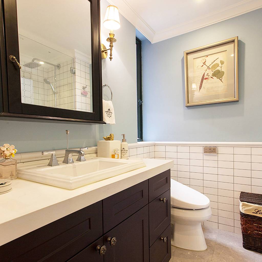 卫生间的色调是卧室的延续，白色与蓝色的墙面透露着清爽浪漫的气息，深色的卫浴柜内敛沉稳，质感厚重。