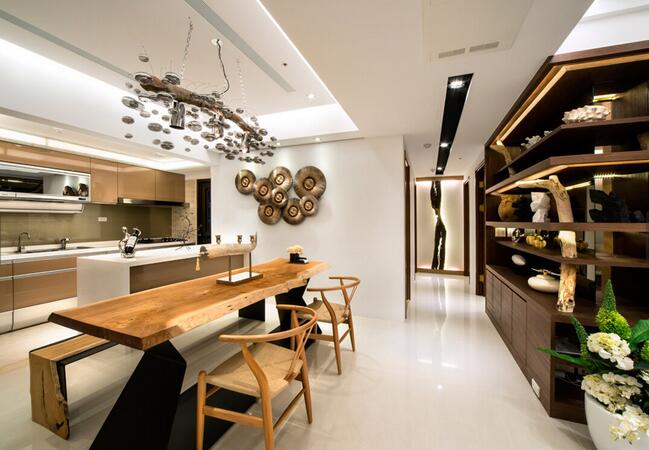 设计师将客厅与餐厨区连结，并在端景主墙上以金黄木条及明镜相搭配，构建刻划著温润感与现代风相融合的质感。