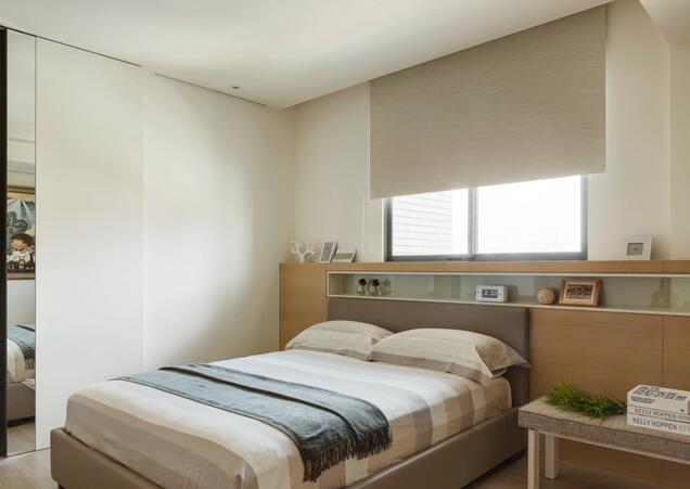 次卧的设计让空间回归了原始的安然和宁静的气质，床头的比例展示柜装饰了生活生动的情趣。