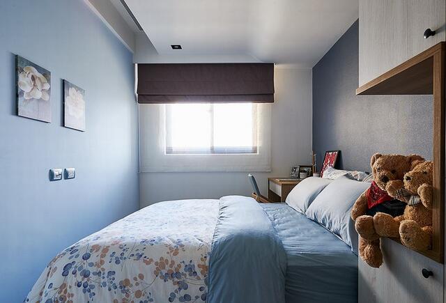 床头床尾两侧墙面分别以浅蓝色漆与进口壁纸做铺陈，为儿童房营造了简单又不失质感的空间个性氛围。