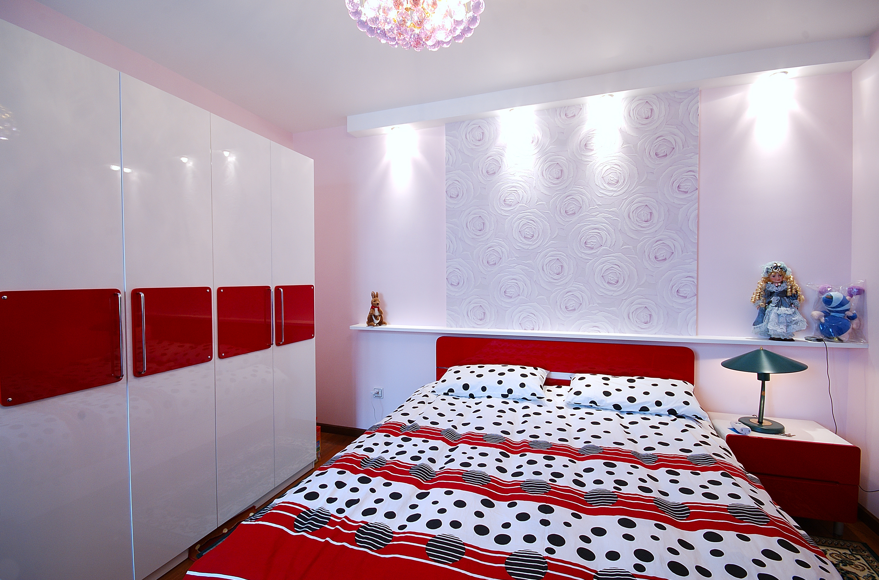 次卧的设计调皮而温馨，床头墙面的玫瑰花图案优雅而低调。