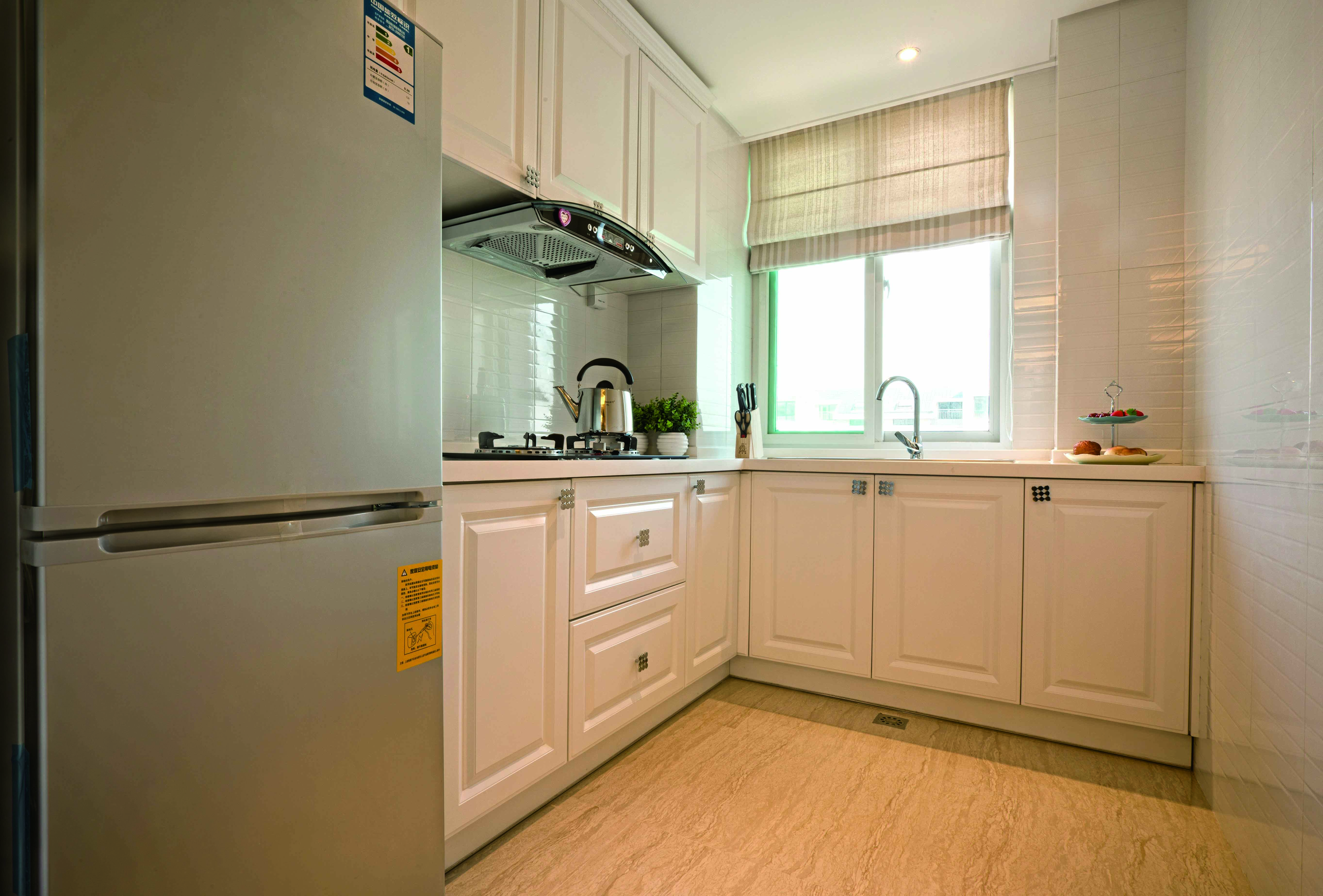 米白色的厨柜有些欧式的感觉，地面沿用了客厅地砖，有延伸视觉的效果，会显得空间更大。