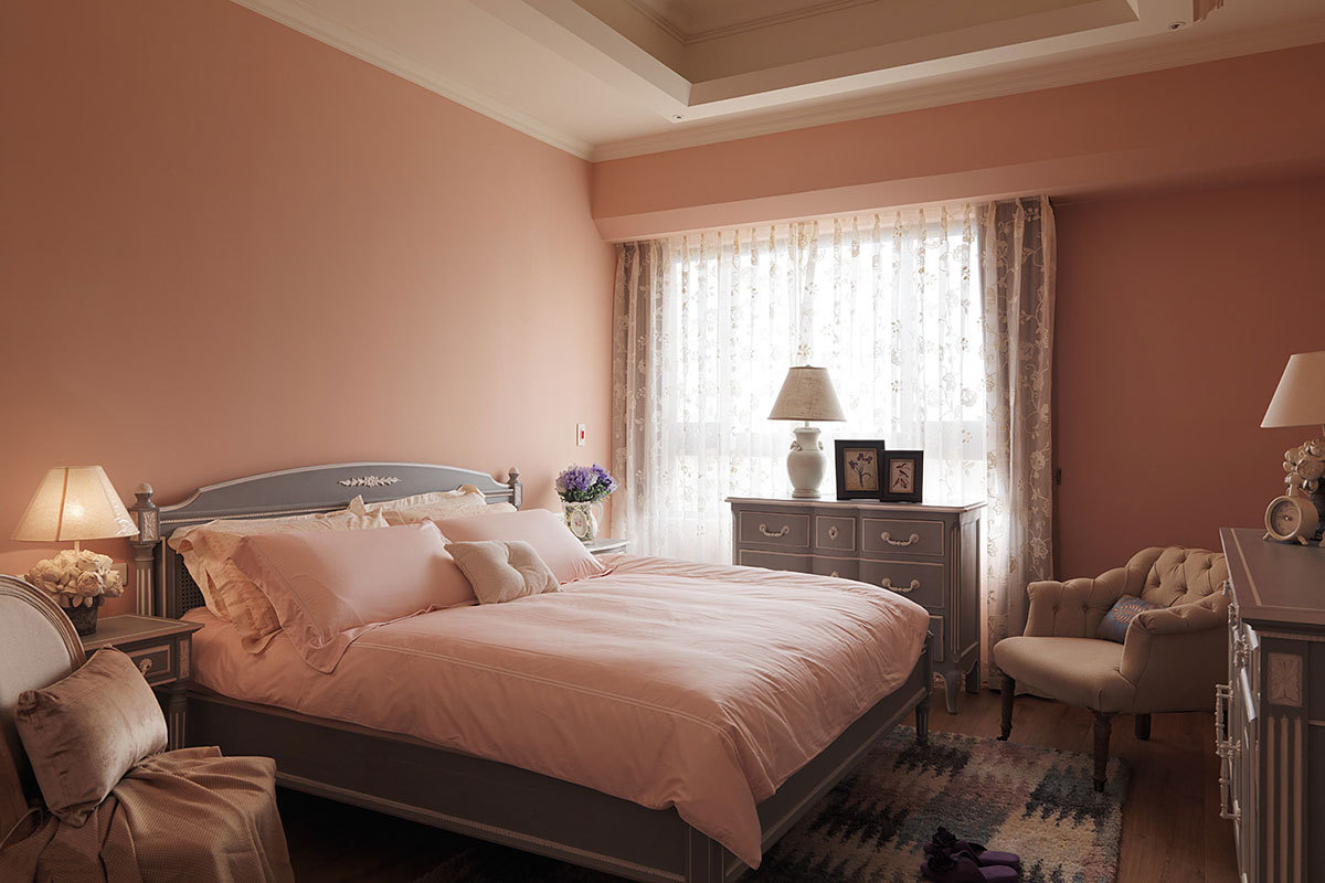 粉橘色系的主卧房中，搭配藕紫色的古典家具与床组，呈现脱俗的美式风情卧房。