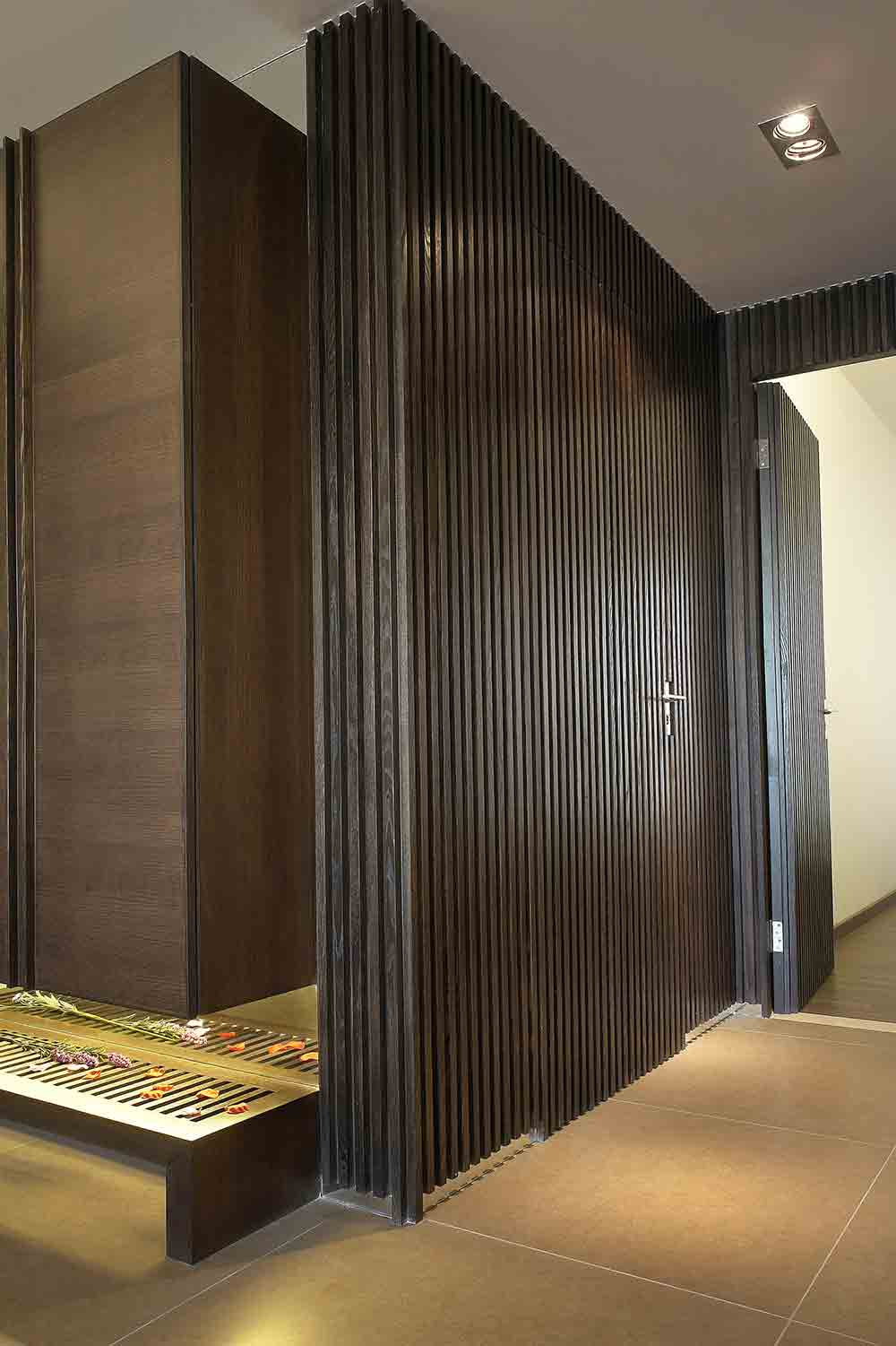 走廊以深色条状木纹妆点，将卫生间的门巧妙藏在其中。