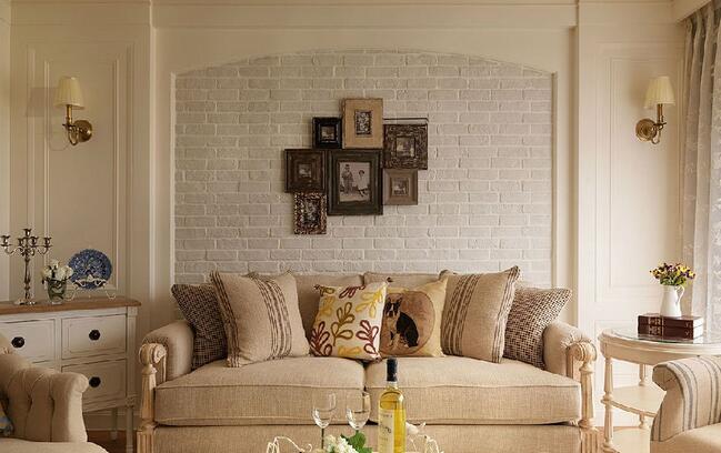 沙发背景墙用浅灰色文化石铺陈，简化的拱门式设计高贵而精美。照片墙的装饰以怀旧为主题，木质相框将时光的质感丰富展现。