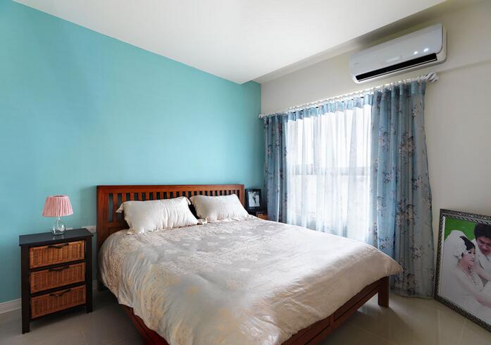 蓝色的床头主墙配合木质床板、藤编床头柜等颇具休闲质感的设计营造了度假般的生活氛围。