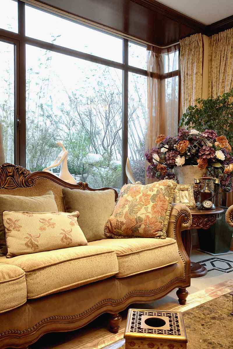 软皮沙发搭配方形靠枕，舒适高贵。旁边的瓷瓶里插着鲜艳纷繁的鲜花，使整个客厅显得充满生活气息。