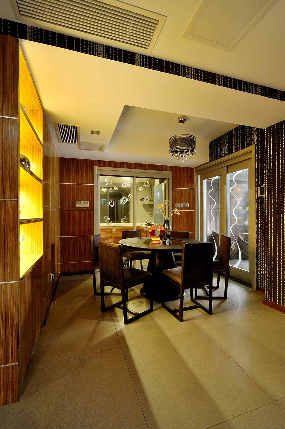 餐厅的设计依旧是暗色的格调，大面积的透明移门和带有光带的镂空隔断增加了空间的通透性。