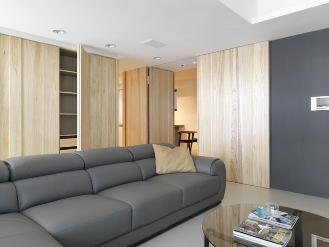 墨黑色的立面，灰色的沙发，浅灰色的地面，三者形成丰富而内敛的层次，搭配梧桐木自然温润的温度，延伸出客厅立面的风景，成为空间焦点。