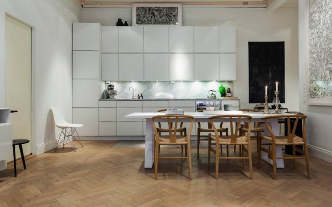半开放式的白色厨房，与原木色的餐椅，结合成舒服的色调。