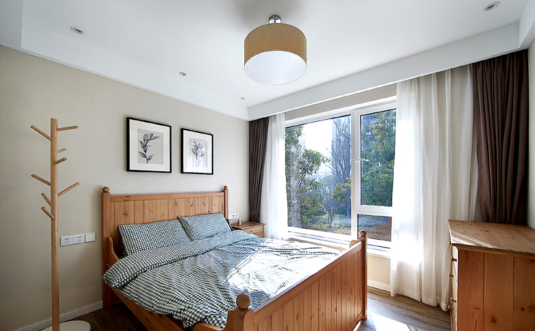 次卧的家居都是木质的，双人床，挂衣架，橱柜，地板，全是木系的自然颜色。