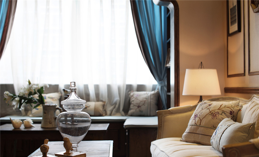 蓝白的飘窗，为客厅提供了自然照明。米黄的布艺沙发上睡一觉，做一个诗一样的梦。