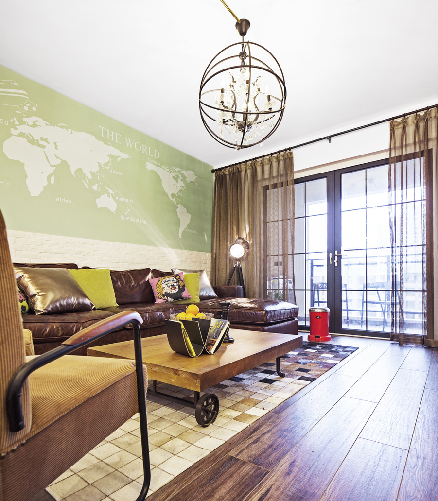 烤漆色的沙发和金属质感的圈形灯具，把浓郁的金属气息带到家里。沙发背景墙的世界地图又增添了现代气息。