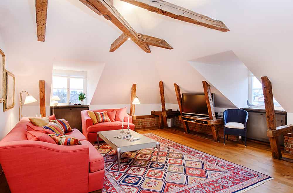 客厅格局不落俗套，并有红色沙发和丰富图案的地毯形成强烈视觉冲击，让人感觉温馨。