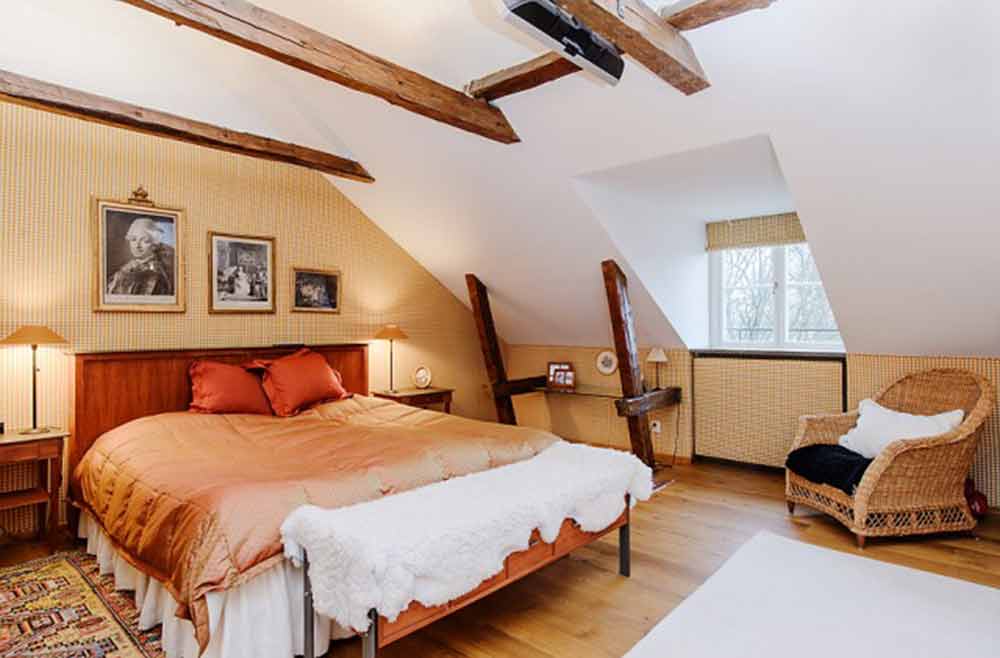 卧室墙面是米黄色的，与暖色调的被套地毯形成呼应，整体温馨。