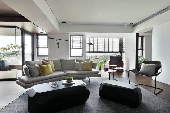 以灰色为客厅奠定低调大气的主基调，再以黄色的抱枕和绿色小盆栽让空间增添了一点小清新。
