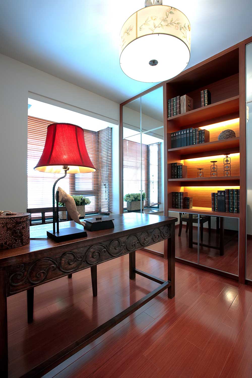 书桌和书柜都是红木材质，有少量典雅花纹，线条简洁，不落俗套。