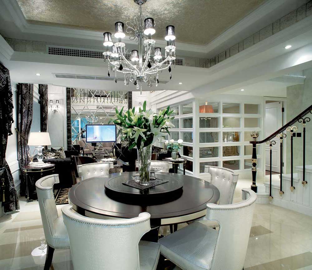 餐厅乳白色的椅子，白色的欧式风格吊灯，搭配起来很和谐。餐厅位于客厅之上，拾级而上，体现层次感。