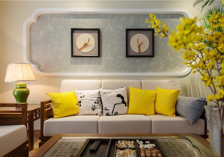 沙发背景是重复的端景造型，梅花点状的壁纸和小鸟装饰画完美结合，明黄色靠垫点缀了整个空间，提升了室内亮度。