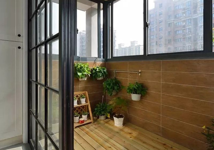 宽敞的阳台，黑色拉门与木质地板的完美结合，搭配绿色小植，是整个房子中又一道风景线。