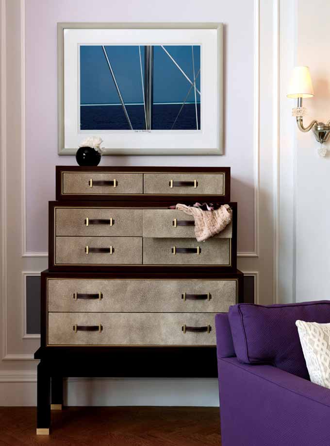 收纳柜设计师可以选择深棕色的木柜，再加上简单的艺术画，将设计感突出。