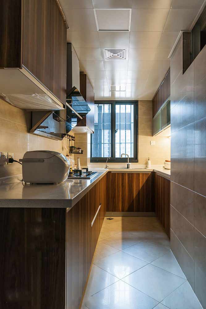 木质橱柜使厨房空间看上去更有质感，同时白色台面让整体看起来更整洁。