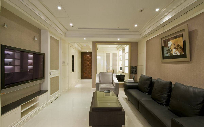 客厅延续现代风格，抛光石英砖持续将视觉引领入内，沙发及电视主墙采用进口壁纸搭配，温润的木头色，为简约空间注入一股暖流。