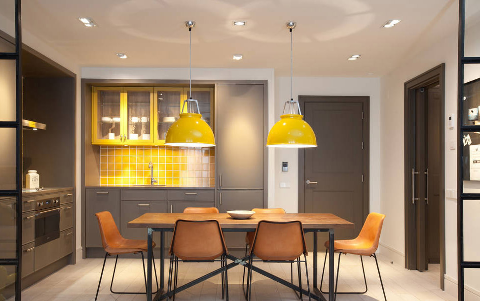 用棕色餐桌椅和黄色灯具暖化空间。提亮空间视觉促进味蕾。