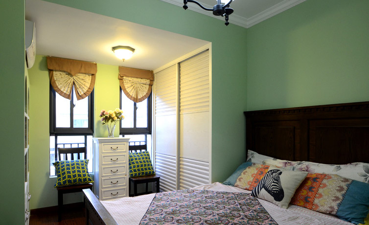 卧室将美式现代分格展现地淋漓尽致。绿色的墙面很有不同的独特感。双开窗的设计很有韵味。移门衣柜也保持了收纳的强大能力~